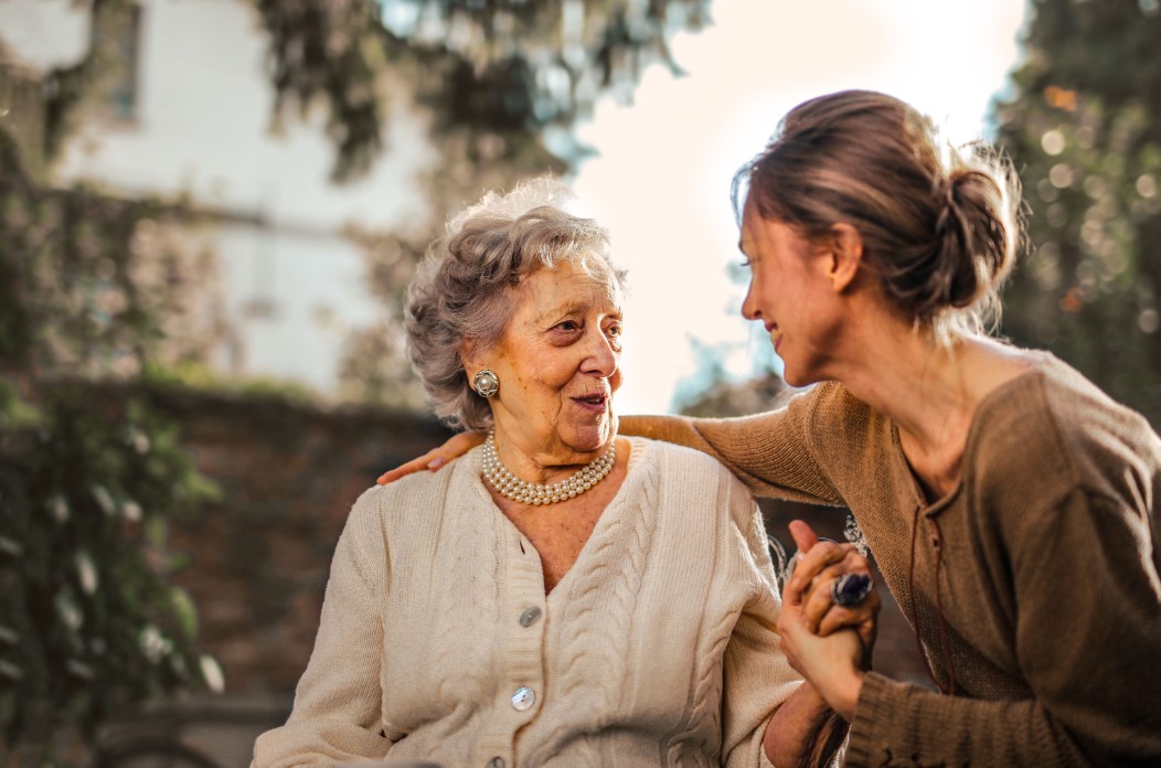 Older adult and companion sharing a warm conversation at home